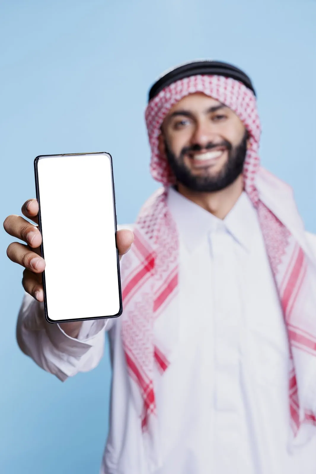 A smiling man holding up a smartphone