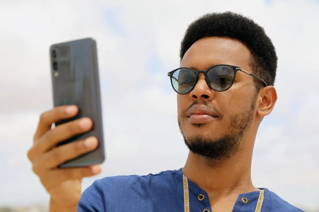 A Somali man using his smartphone outdoors in Mogadishu